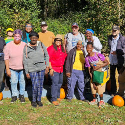 Kim standing in a field with a large crowd and pumpkins