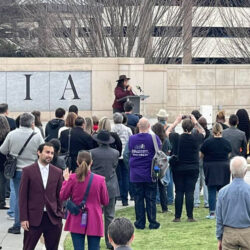 Kim at the courtyard in front of the State Capitol speaking to a large group of people