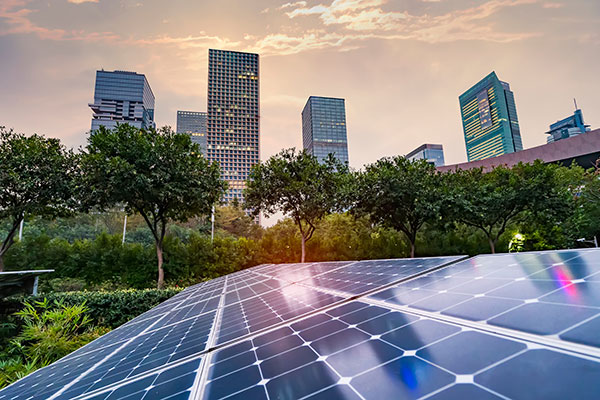 Close up view of a solar panel with a view of downtown in the background nearby